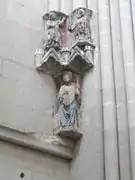 Photographie en couleurs d'un groupe de sculptures murales polychromes dans une église.