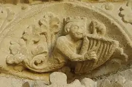 Photographie en couleurs d'une sculpture représentant un personnage couronné jouant de la lyre.