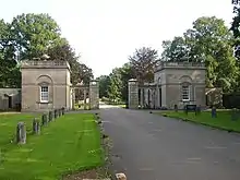 Photo. Entrée d'un domaine : grille d'entrée flanquée de deux pavillons
