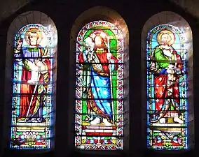 Triptyque des vitraux au-dessus du portail. Jésus, le Bon Pasteur, entre saint Paul à gauche et saint Pierre.