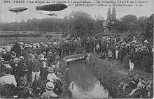 Revue militaire du 14 juillet 1909. En arrière-plan, le moulin, vestige de l'abbaye royale de Longchamp, est toujours présent de nos jours, de même que le petit pont.
