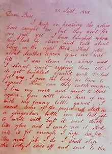 Lettre écrite à l'encre rouge sur papier.