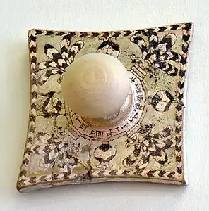 Carreau avec pommeau avec décor glaçuré représentant des motifs floraux, et inscription cunéiforme au nom d'Assurnasirpal II. Assur, Pergamon Museum.