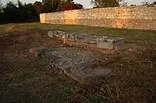 Vue de pierres en grand appareil de grès matérialisant le seuil d'entré d'un bâtiment antique.