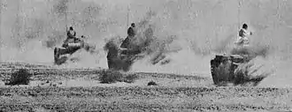 Photographie montrant trois chars égyptiens avançant à pleine vitesse sur une route du désert du Sinaï.
