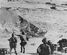 Photographie montrant des soldats égyptiens dans le désert du Sinaï tirant des chariots de bois.