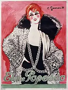 Affiche de 1925 peinte et signée par Charles Gesmar, où sur un fond rose une jeune et souriante Elvire Popesco, d'une élégance emblématique du Paris des Années folles, très maquillée, coiffée à la garçonne, les cheveux roux, semble poser avec une assurance crâne, les mains sur les hanches. Elle porte des boucles d'oreilles pendantes avec perles et est vêtue avec une veste noire richement brodée, avec un épais col de fourrure noire. Sur une épaule est posée une écharpe blanche, peut-être de soie.