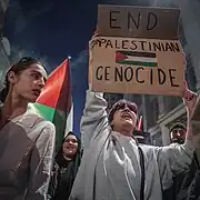 Manifestant tenant une pancarte « End Palestinian Genocide » à Londres, le 9 octobre 2023.