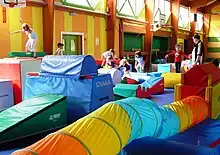 Photo couleur d'un gymnase rempli de matériel de gymnastique multicolore et d'enfants y jouant