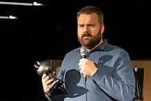 photographie couleur de Robert Kirkman avec en main le trophée reçu à Angoulême