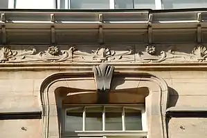 Couronnement d'une fenêtre du deuxième étage et détail de la frise : palmettes, marguerites et feuillages ondulants