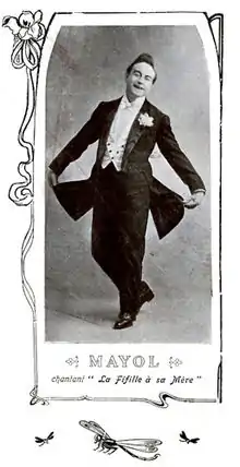 Photographie en médaillon d'un chanteur en costume, prenant une pose, l'image étant sous-titrée et entourée d'une bordure à motif végétal.