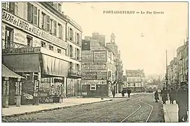 La rue Grande d'où l'on aperçoit le « Bazar de l'hôtel de ville et Nouvelles Galeries ». Sur le balcon de la maison à l'angle, on aperçoit également l'enseigne « Pianos Musique » du magasin Legrand.