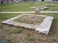 Plusieurs pierres plates entourant un carré de terre d'environ 1 m².