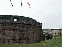 photographie de la Tour des Bourgeois surmontée de trois drapeaux.