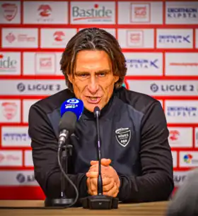 Photographie de profil de Frédéric Bompard lors d'une conférence de presse.