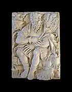 Bas-relief d'un homme assis enchainé.