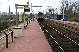 Voies et quais avec le départ d'un train Transilien en direction de Malesherbes.