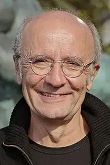 Portait photo d'un homme souriant, portant des lunettes.