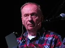 un homme de 65 ans, souriant, plan poitrine