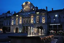 Photographie d'un théâtre ancien éclairé, de nuit.