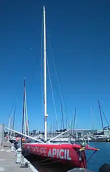 Vu de trois quarts face, en entier, voilier rouge amarré au ponton.