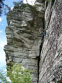 une personne escaladant une montagne.