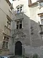 Angle d'une cour de bâtisse Renaissance&nbsp;: fenêtres à meneau et porte d'entrée ornée de pilastres et fronton.
