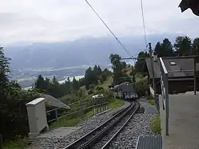 Vue d'un train arrivant en gare de Haut-de-Caux depuis le quai de ce même arrêt.
