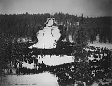 Une foule autour d'un tremplin de saut à ski.