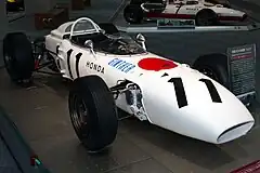 Photo prise depuis l'avant, de la Honda RA272, un châssis blanc de forme tubulaire