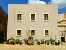 photographie couleurs : un bâtiment jaune avec six fenêtres