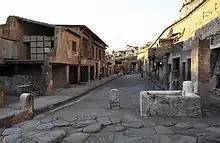 large voie bordée de trottoirs et de bâtiments à un étage