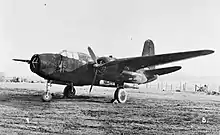 Photographie noir et blanc d'un avion au sol. Le nez de l'avion abrite une antenne radar en râteau.