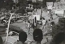 Cliché noir et blanc. Personnages sur un port depuis un navire.