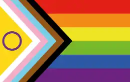 Drapeau des fiertés LGBT+, incluant le drapeau intersexe (rond violet sur fond doré), le drapeau transgenre, ainsi que deux bandes marron et noire symbolisant l'antiracisme (2021).