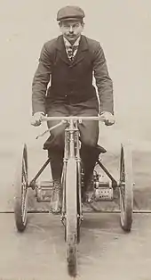 Photo de Marcellin prenant la pause au guidon de son tricycle Phébus.