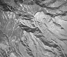 Photo noir et blanc du cratère d'un volcan, vu du ciel.