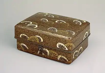 Coffret à décor de roues plongées dans l'eau, XIIe&nbsp;siècle. Bois laqué noir maki-e, laque dorée et nacre 22,4&nbsp;×&nbsp;13,3&nbsp;cm, musée national de Tokyo.