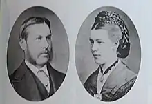 Double médaillon en vis à vis. A gauche : un homme en costume avec une barbe à l'anglaise sans poils au menton. A droite : une femme avec une coiffure relevée élaborée.