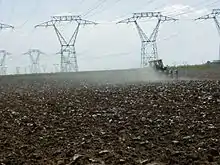 Vue d’un tracteur labourant des champs.
