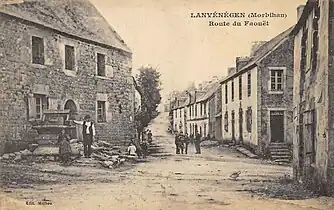 La route du Faouët (actuelle rue Jean Cadic) au début du XXe siècle avec au premier plan le vieux puits aujourd'hui disparu (carte postale Milliou).