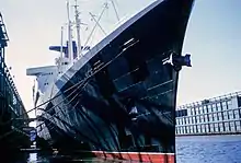 Vue en contre-plongée d'un immense paquebot depuis le quai.