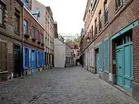 A gauche, l'immeuble du 8, le plus élevé des années 1950, était un atelier de confection jusque vers 1980, la maison derrière peut-être les bureaux et entrée de la filature.