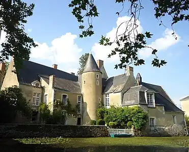 Photographie de l'extérieur d'un manoir entouré de douves.