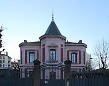 Villa bourgeoise d'un étage. Tourelle octogonale comme centre. Toit central tel un clocher, plat ailleurs.