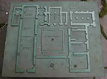 Photographie d'une plaque de bronze sur laquelle figure le plan d'une abbaye.