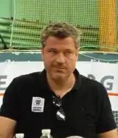 Photo d'un homme vêté d'un polo noir.