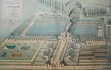 gravure en couleurs montrant les bâtiments d'une usine vues de l'extérieur.