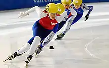 Mara Zini en train de patiner, devant trois autres compétitrices.